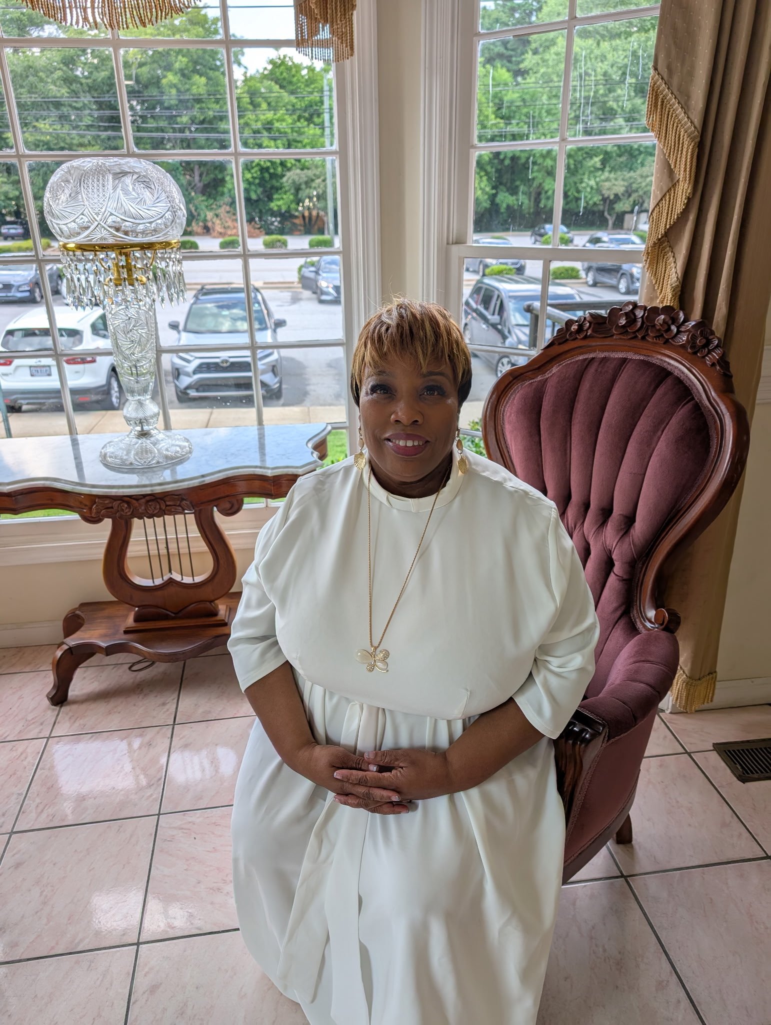 Pastor Joyce Davis sitting in a white dress